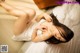 A woman laying on a bed in a white lingerie.