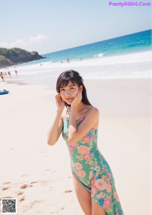 A woman in a floral dress standing on a beach.
