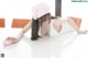 A woman in a pink hat is cleaning a white table.