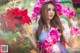 A woman in a blue dress holding a bunch of flowers.