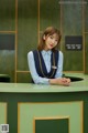 A woman sitting at a desk in a hotel lobby.