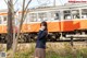 A woman in a school uniform standing next to a train.