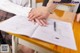 A woman sitting at a desk with her hands on a piece of paper.