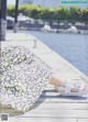 A woman is sitting on a dock with her feet up.