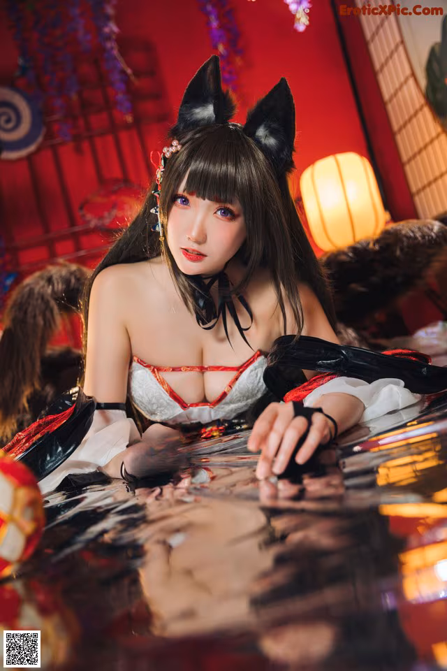 A woman in a cat costume laying on a table.