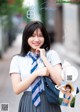 A woman in a school uniform is posing for a picture.